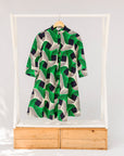 Display of green, black and white abstract print dress.