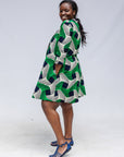 Model wearing green, black and white abstract print dress.
