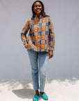 Model wearing orange, navy and white geometric print shirt.
