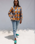 Model wearing orange, navy and white geometric print shirt.