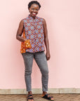 The model is wearing orange, purple, white and black mixed pattern kanga tank
