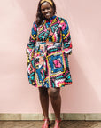 The model is wearing multi colored geometric print dress