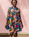 The model is wearing multi colored geometric print dress