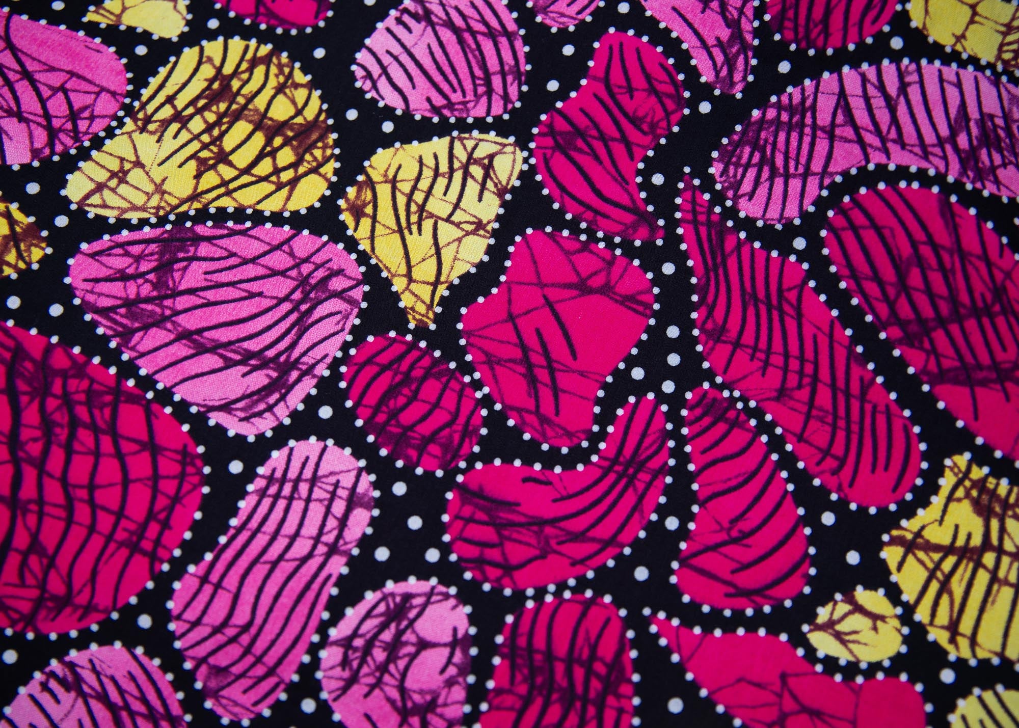 Close up display of black, white, yellow, brown, pink, hot pink and purple bubble print dress