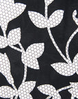 Close up display of  black dress with white and gray leaf print