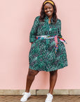 The model is wearing black, green and white geometric print dress