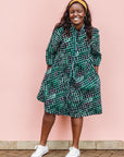 The model is wearing black, green and white geometric print dress