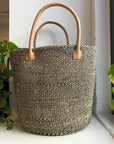 Black and white woven sisal basket with leather handle.