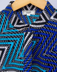 Close up display of blue, aqua and white zig zag print dress.