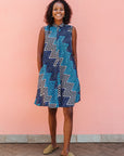 Model wearing blue, aqua and white zig zag print dress.