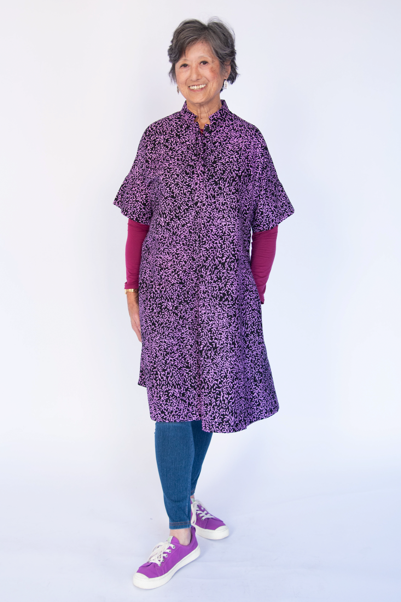 Model wearing purple and black floral print dress.