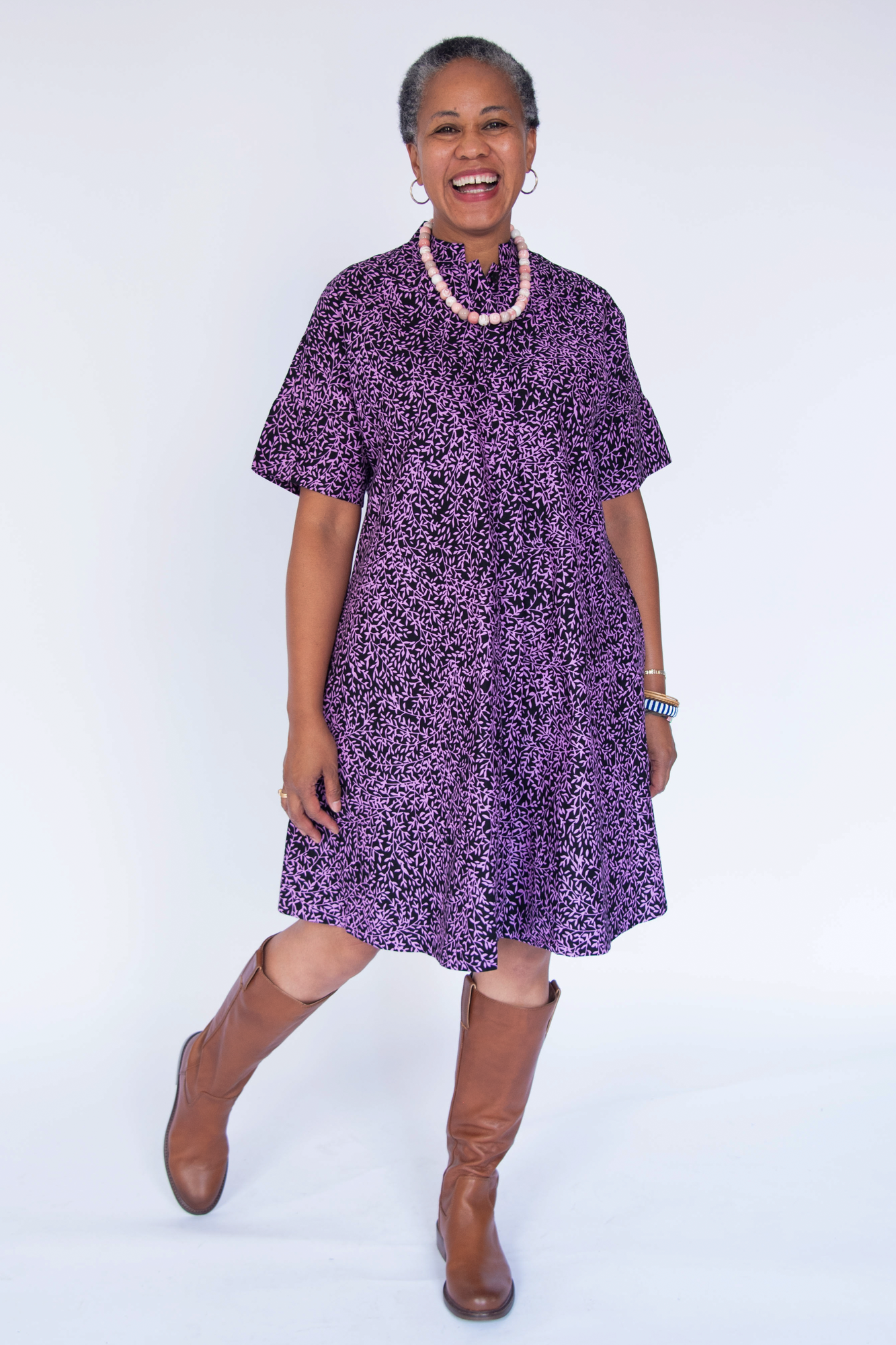Model wearing purple and black floral print dress.