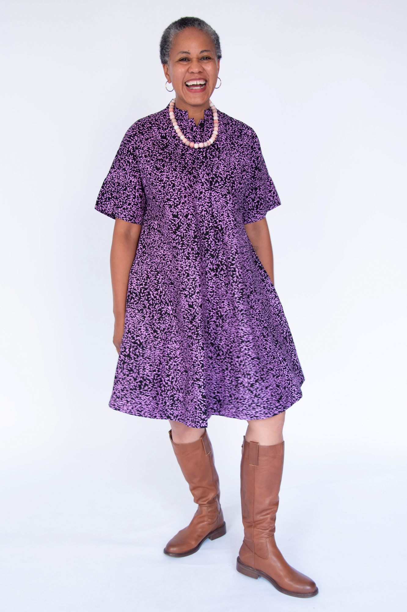 Model wearing purple and black floral print dress.