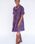 Model wearing purple and black floral print dress.