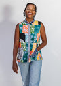 Person wearing a colorful patchwork sleeveless shirt and jeans on a white background