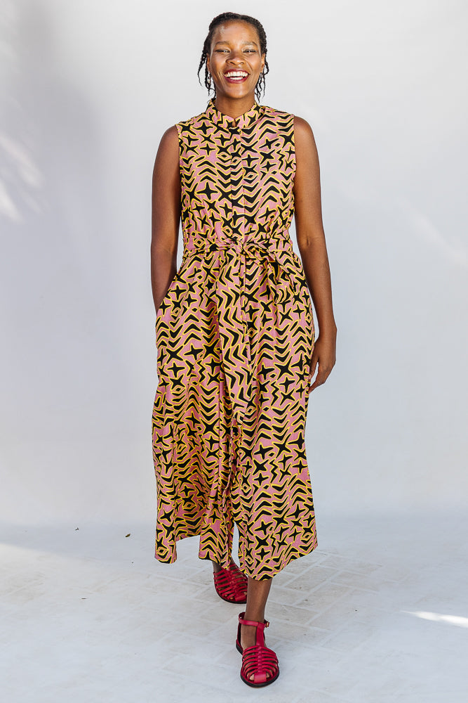 Model wearing beige, yellow and black geometric print dress.