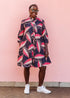 The model is wearing navy blue dress with black, pink and baby pink chrysalis
