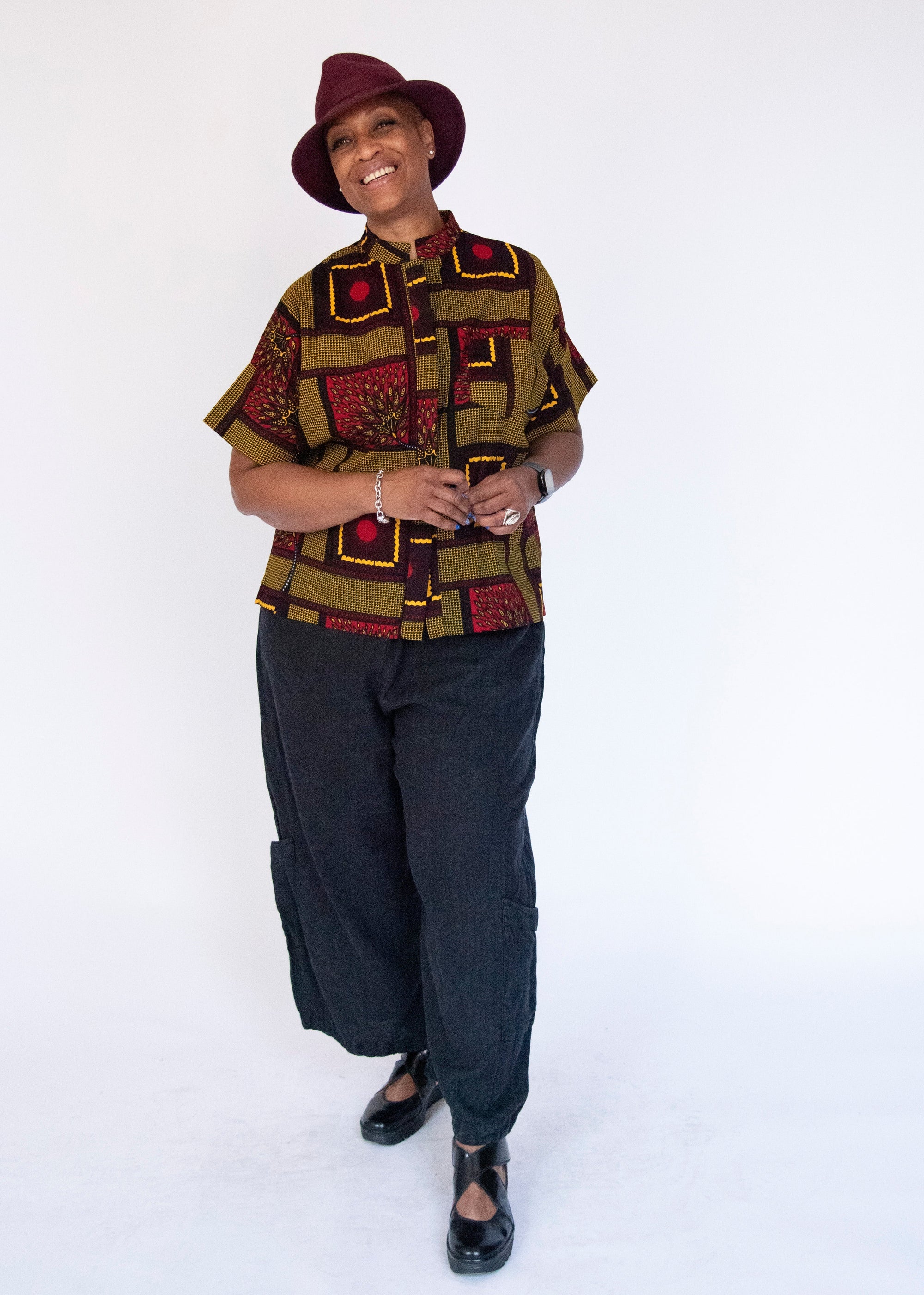 Model wearing yellow, red and black abstract print shirt.