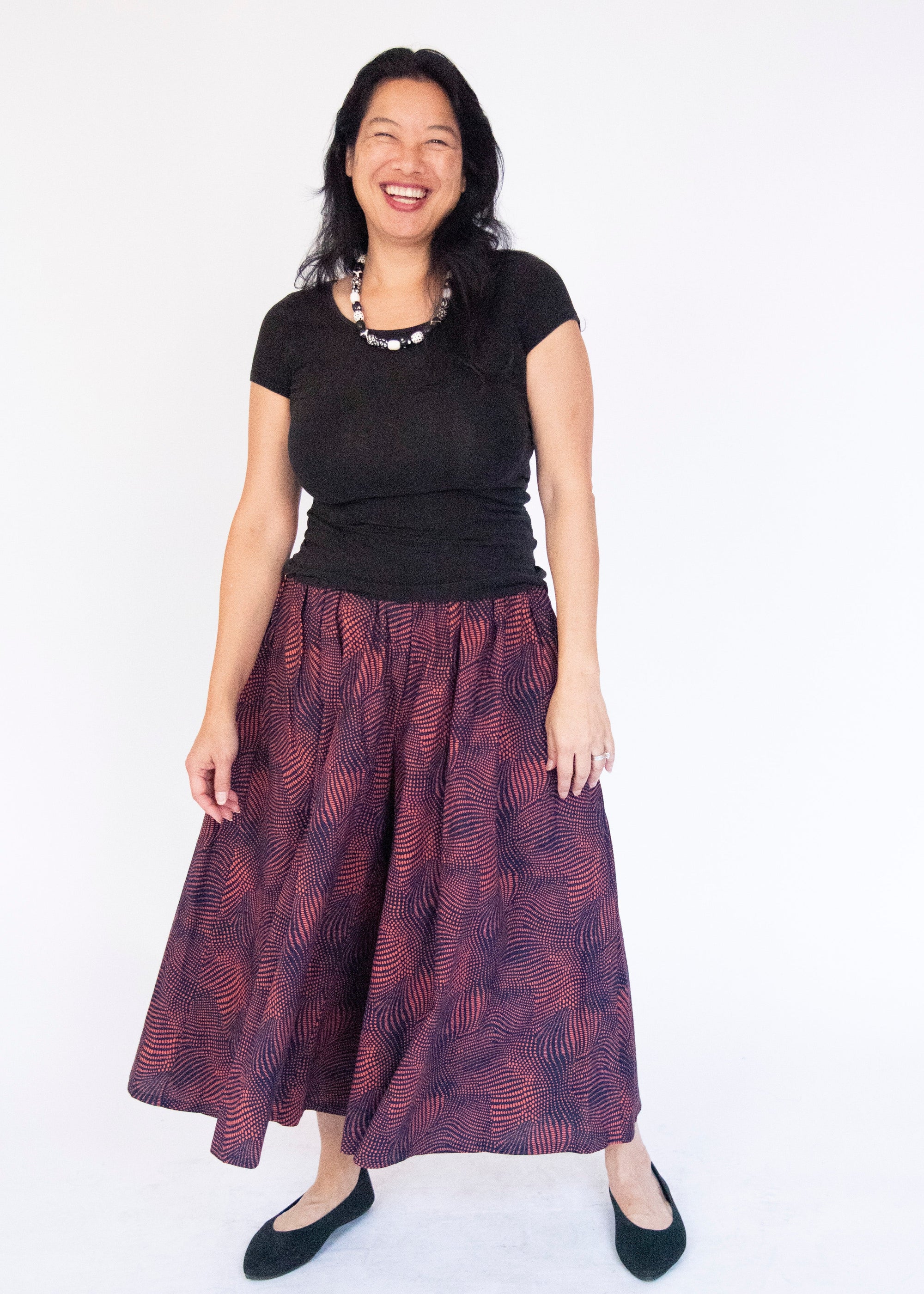 Model wearing navy pants with pink dots.