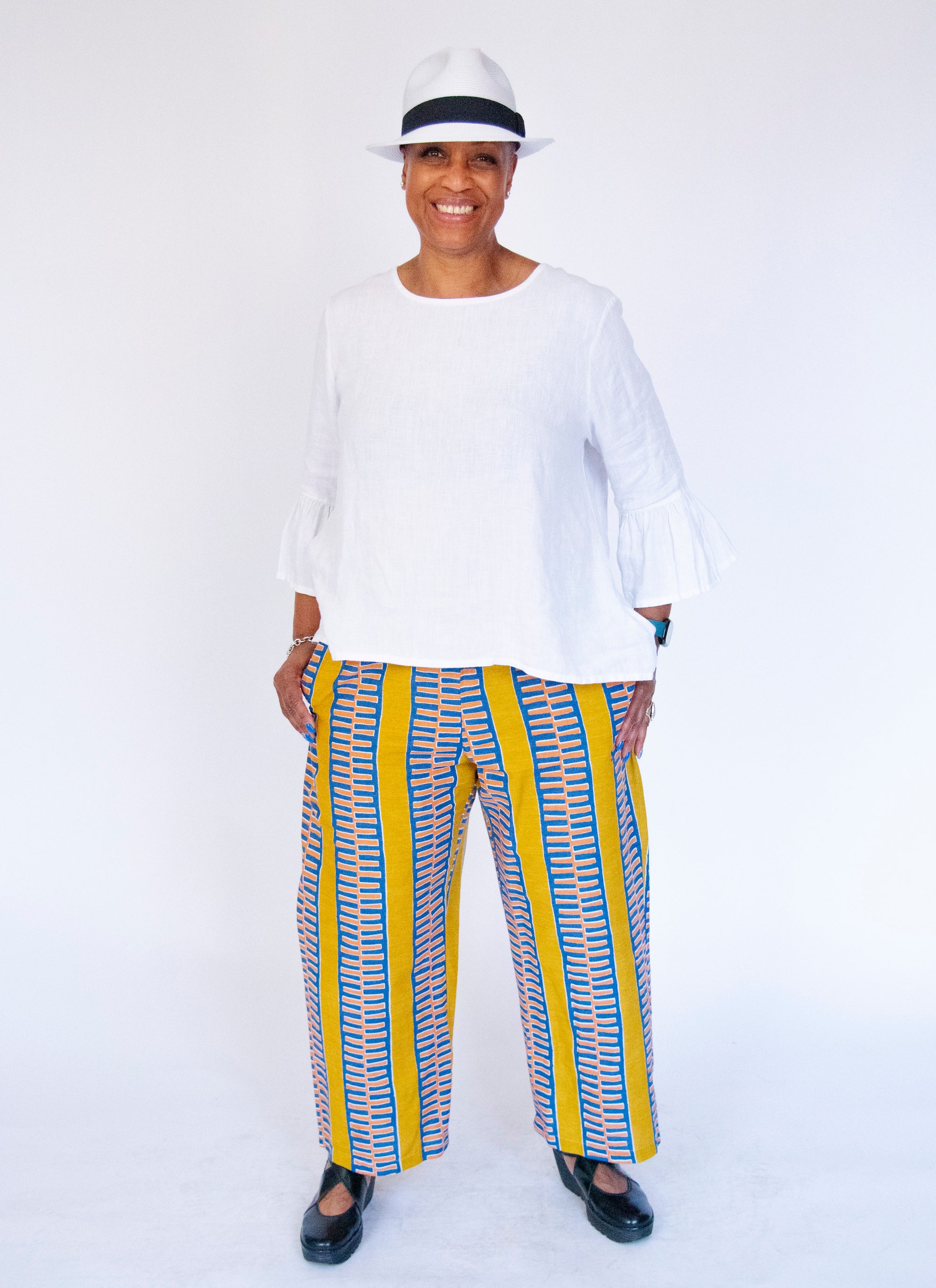 Model wearing yellow pants with blue zig zag pattern.