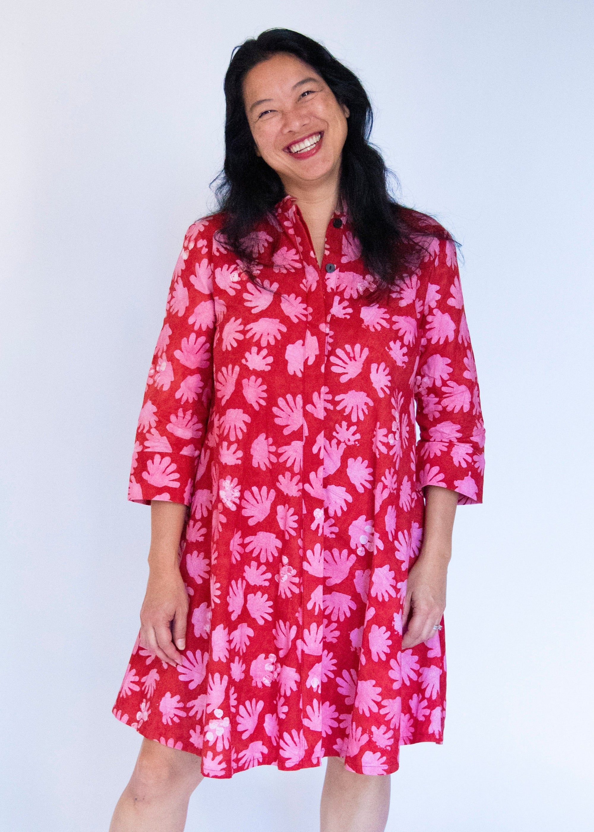 Model wearing red dress with pink flower print.