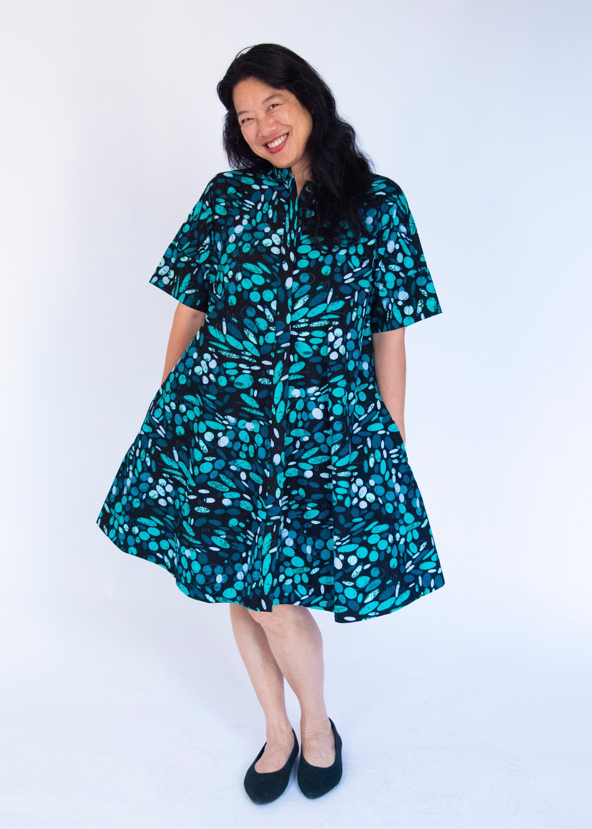Model wearing abstract blue pebble print dress.
