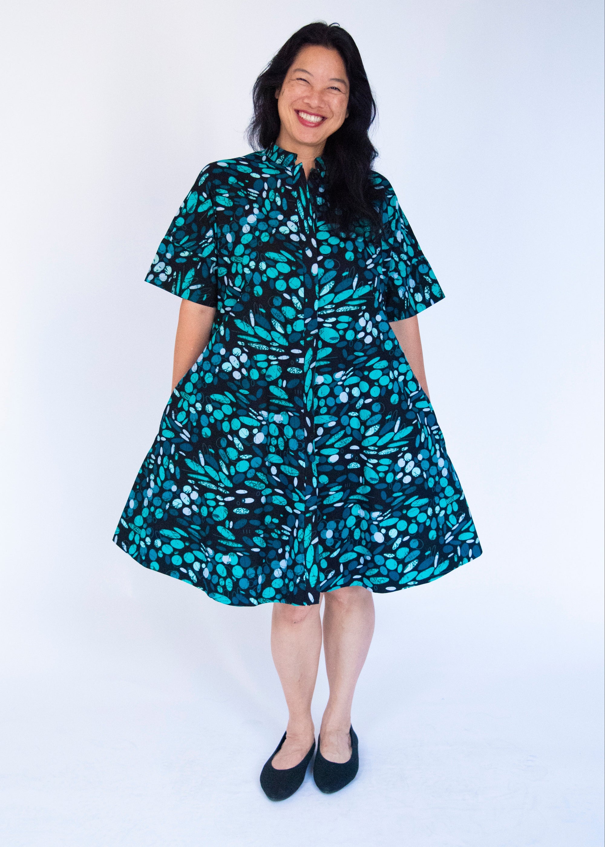 Model wearing abstract blue pebble print dress.