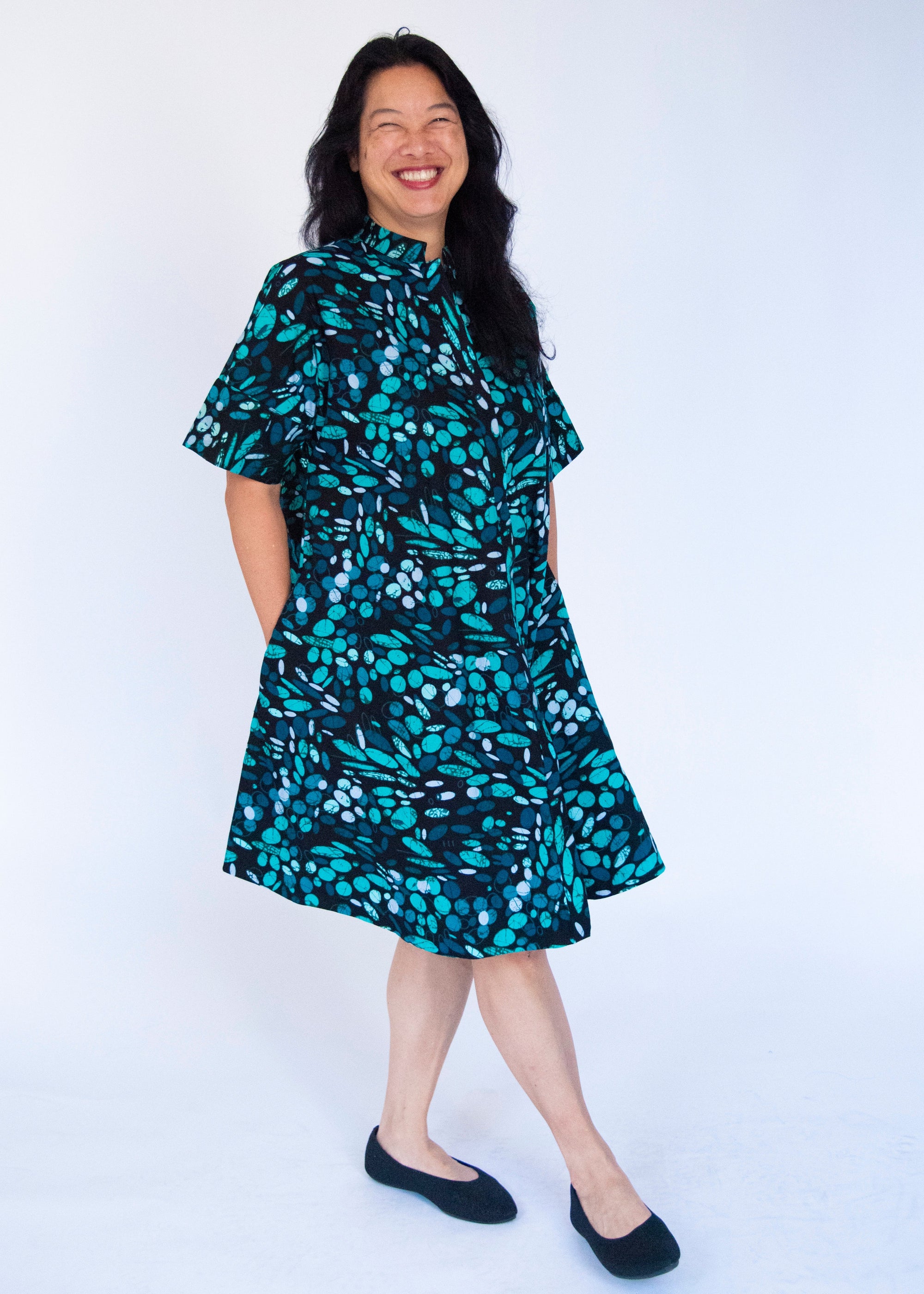 Model wearing abstract blue pebble print dress.