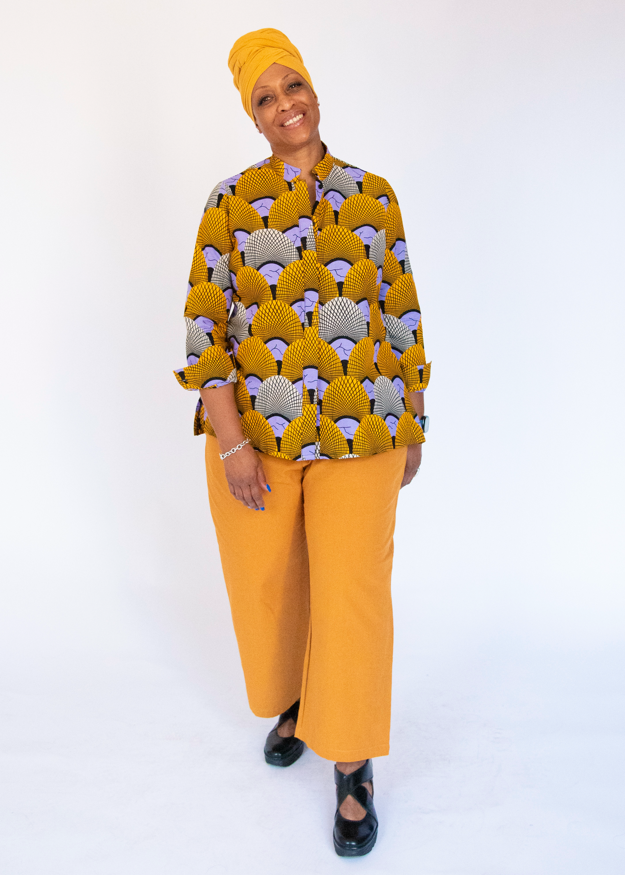 Model wearing long sleeved orange and purple geometric print shirt.