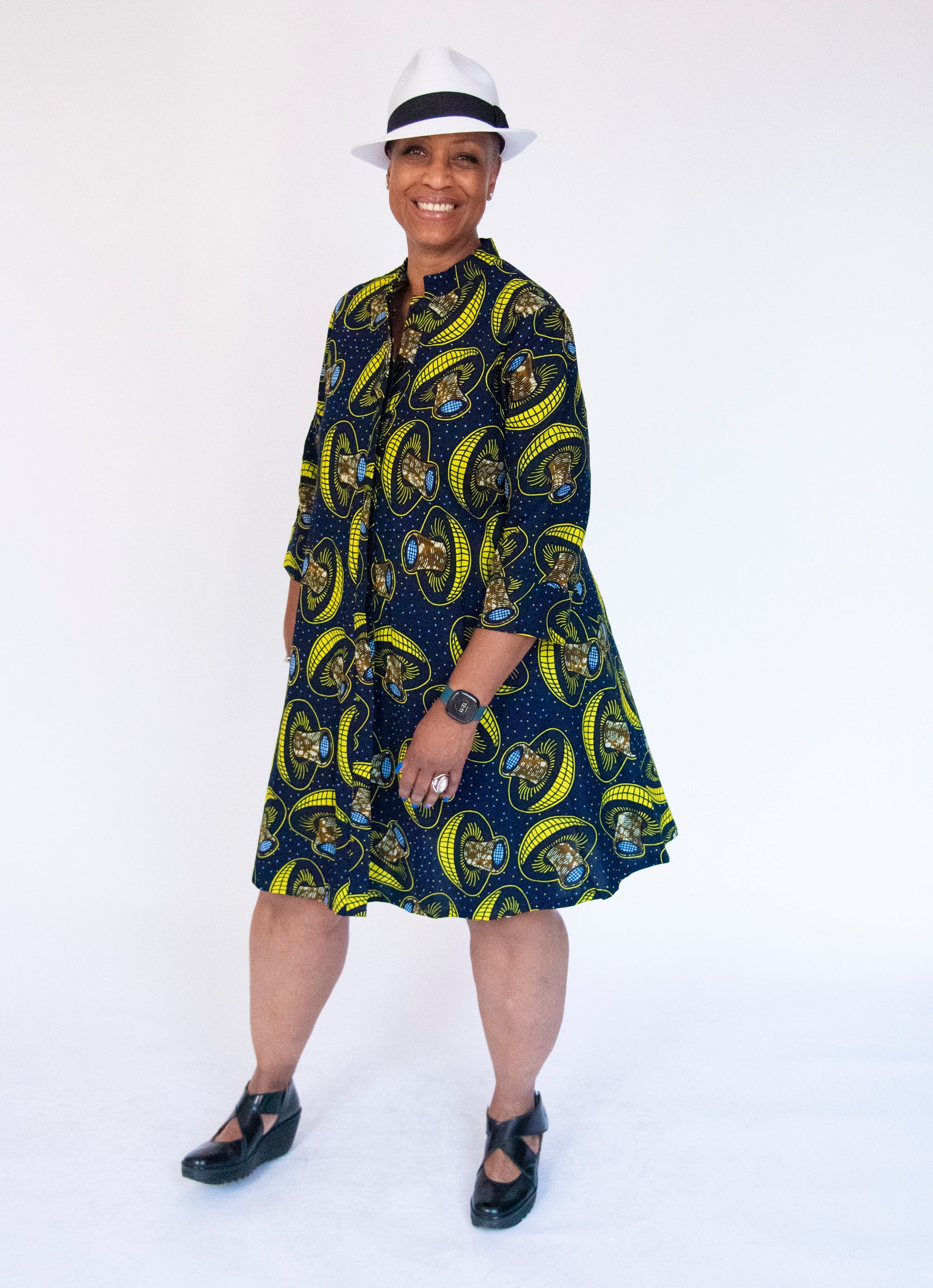 Model wearing navy dress with yellow and brown mushroom print.