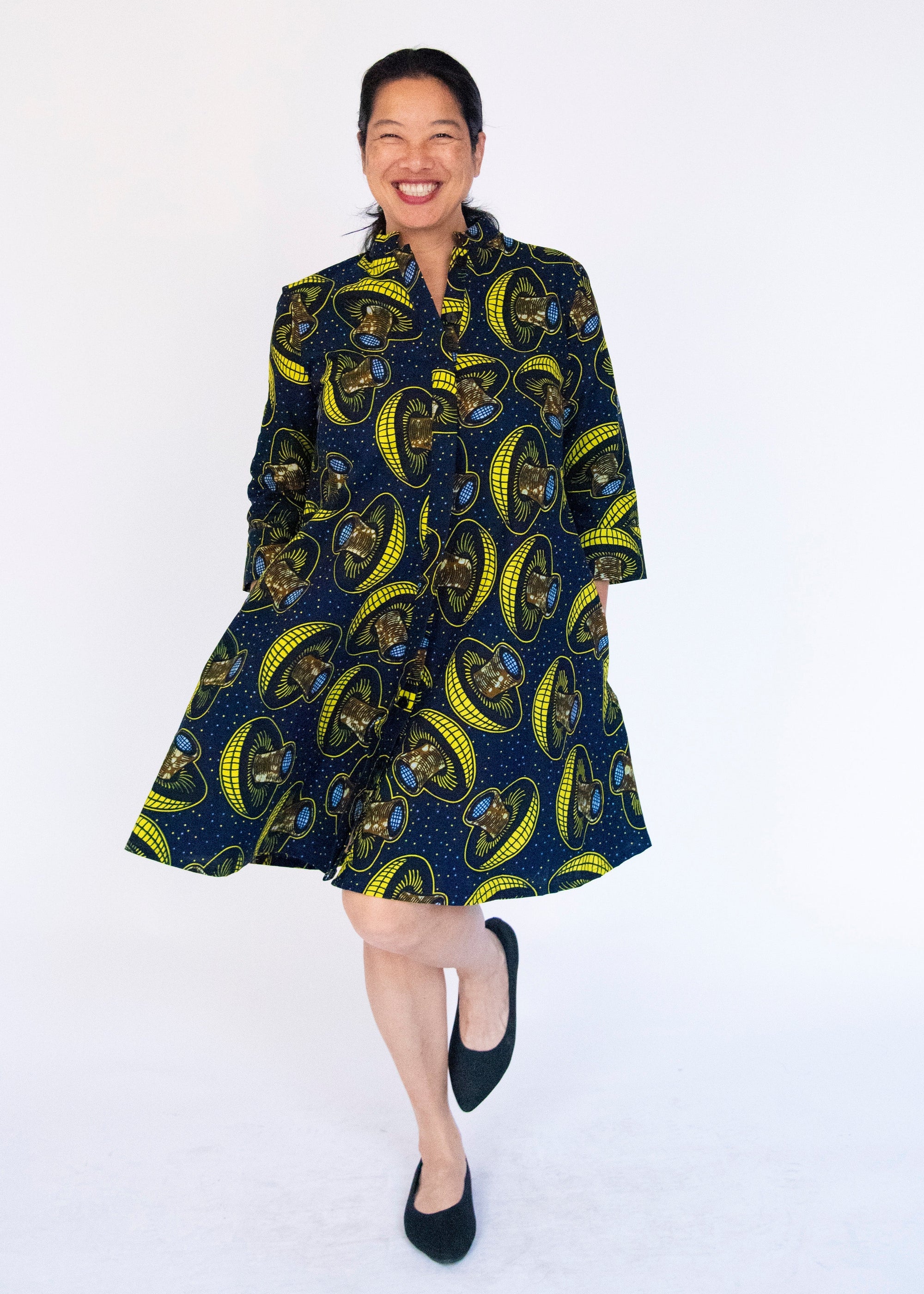 Model wearing navy dress with yellow and brown mushroom print.