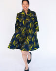 Model wearing navy dress with yellow and brown mushroom print.