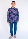 Model wearing long sleeved shirt with purple and green fish print.
