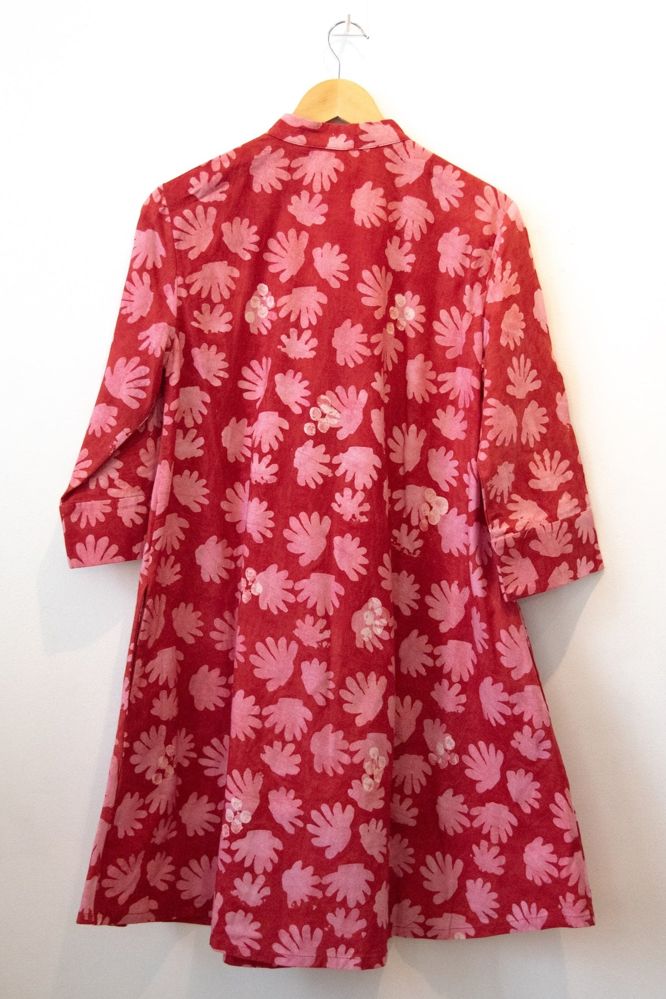 Display of red dress with pink flowers.