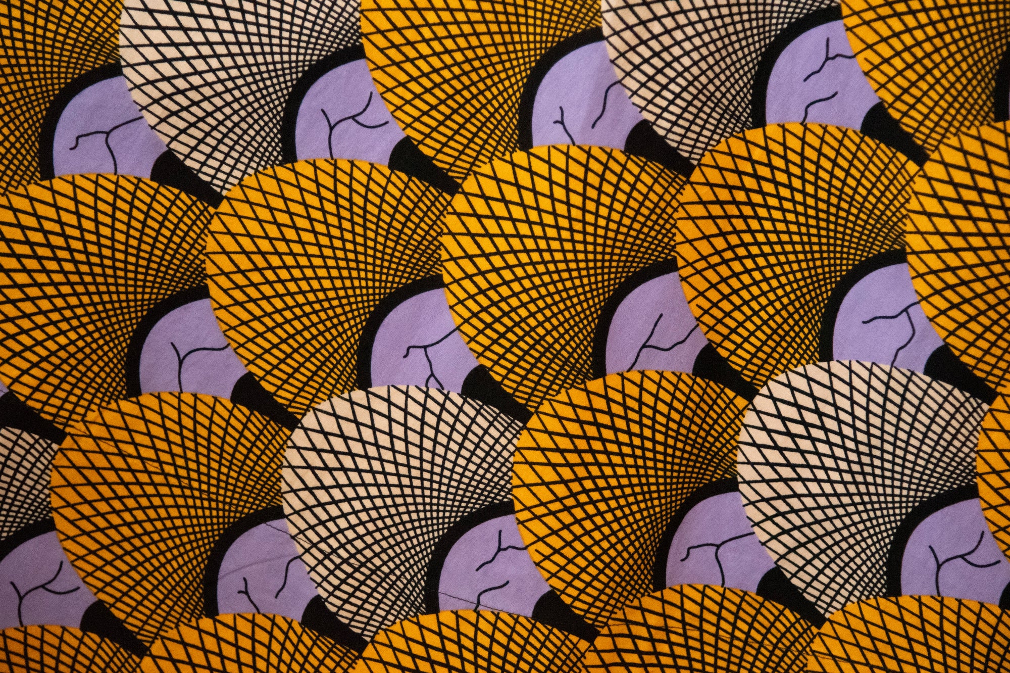 Close up display of long sleeved orange and purple geometric print shirt, fabric.