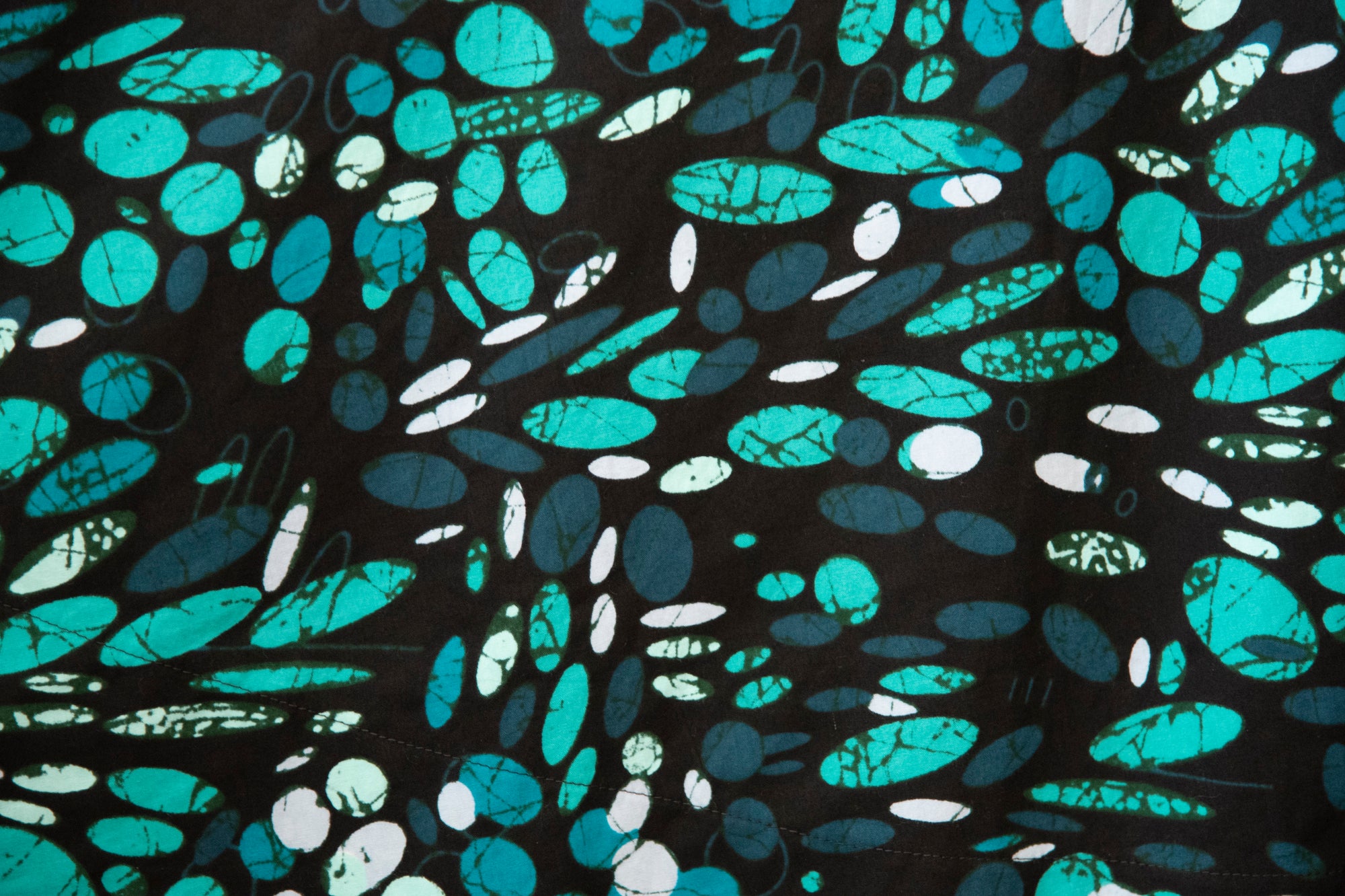 Close up display of abstract blue pebble print dress, fabric.