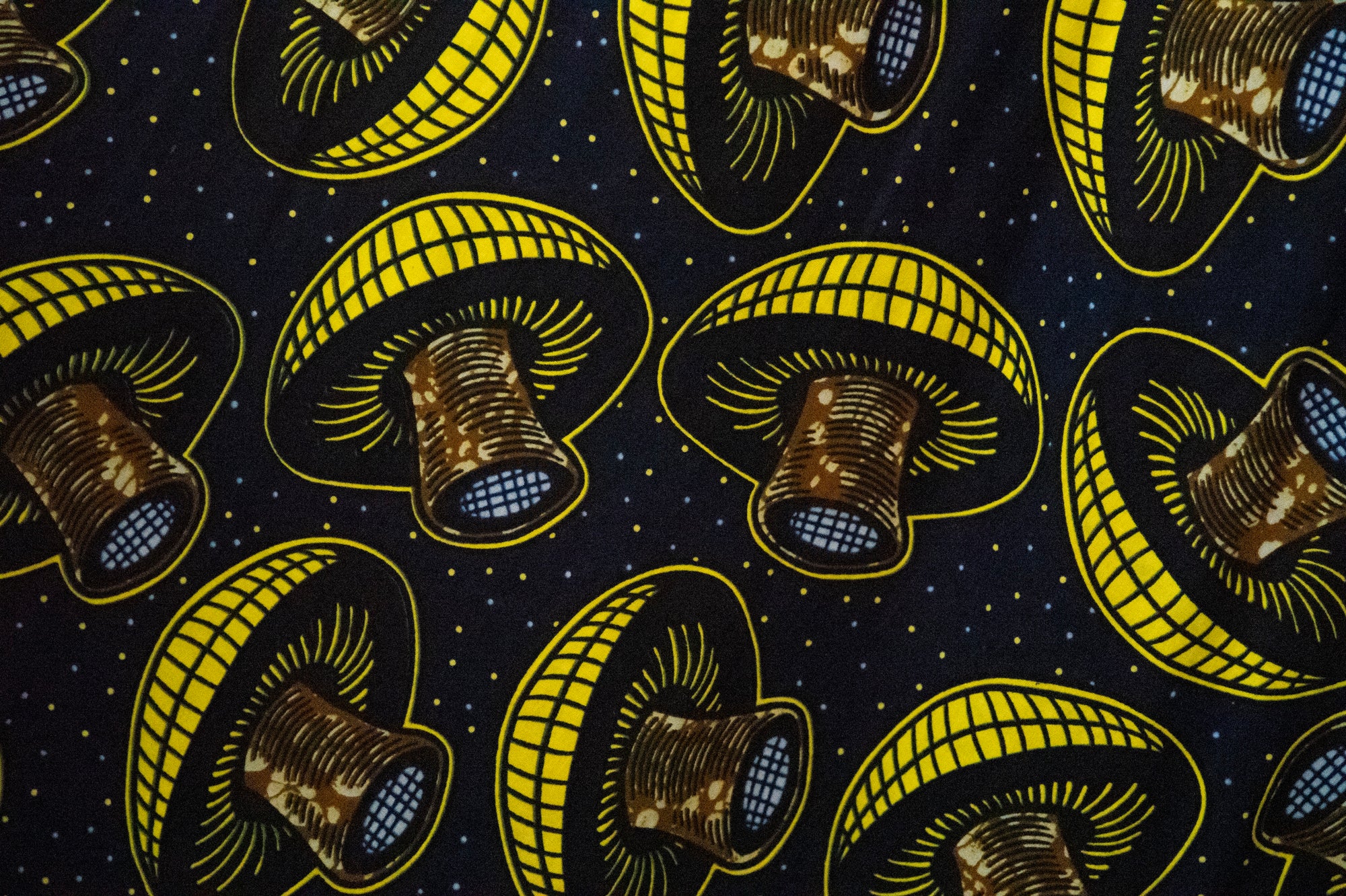 Close up display of navy dress with yellow and brown mushroom print, fabric.