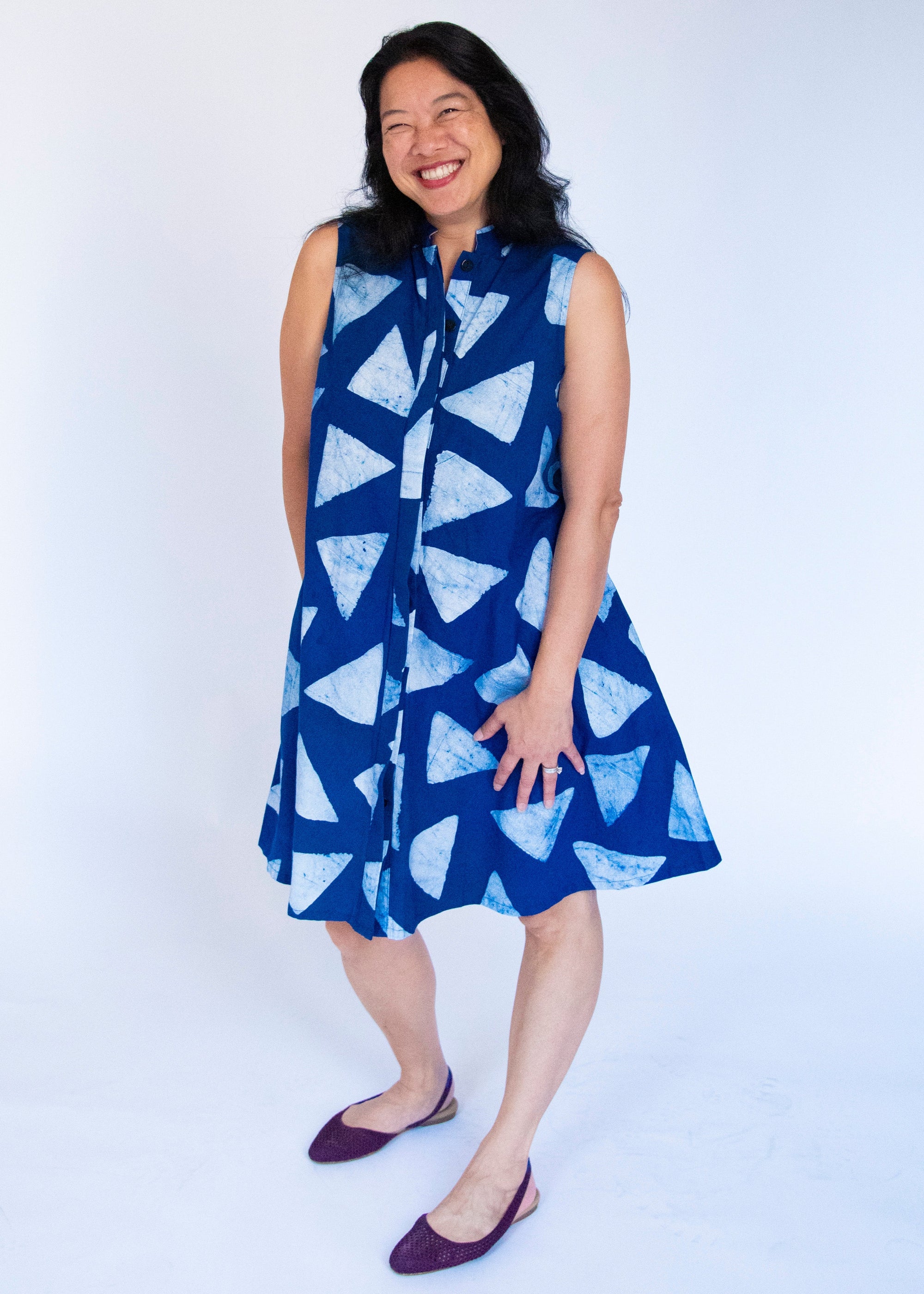 Model wearing blue sleeveless dress with white triangle print.