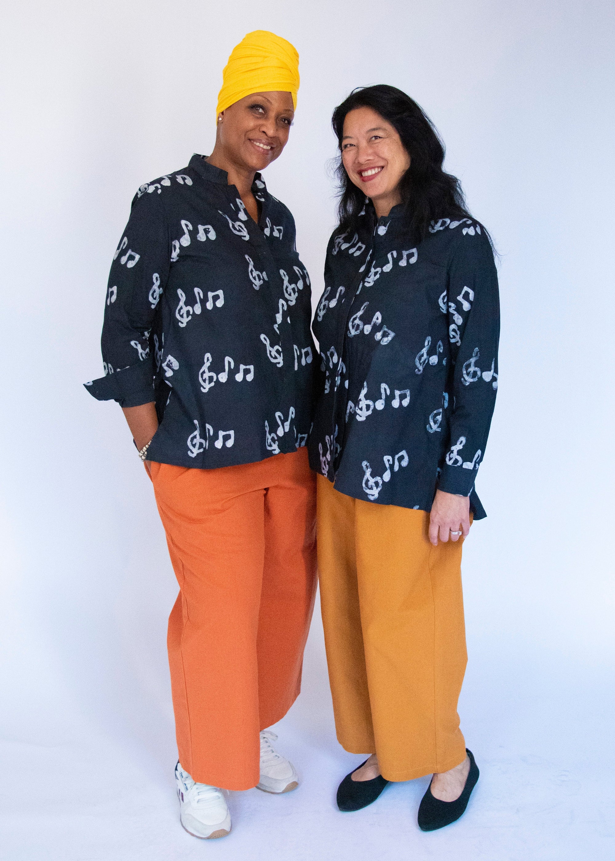 Model wearing black long sleeved shirt with white music print design.