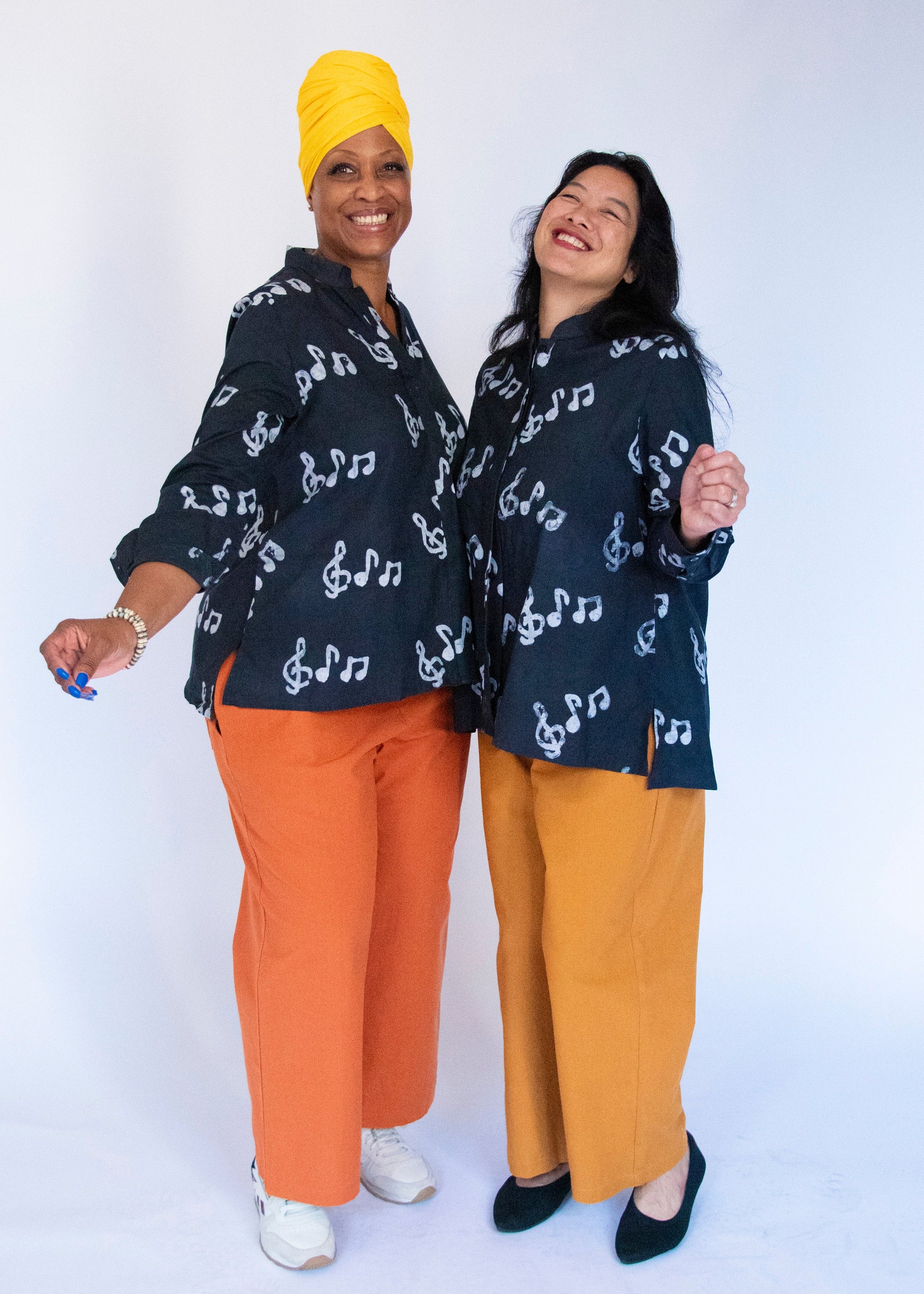 Model wearing black long sleeved shirt with white music print design.