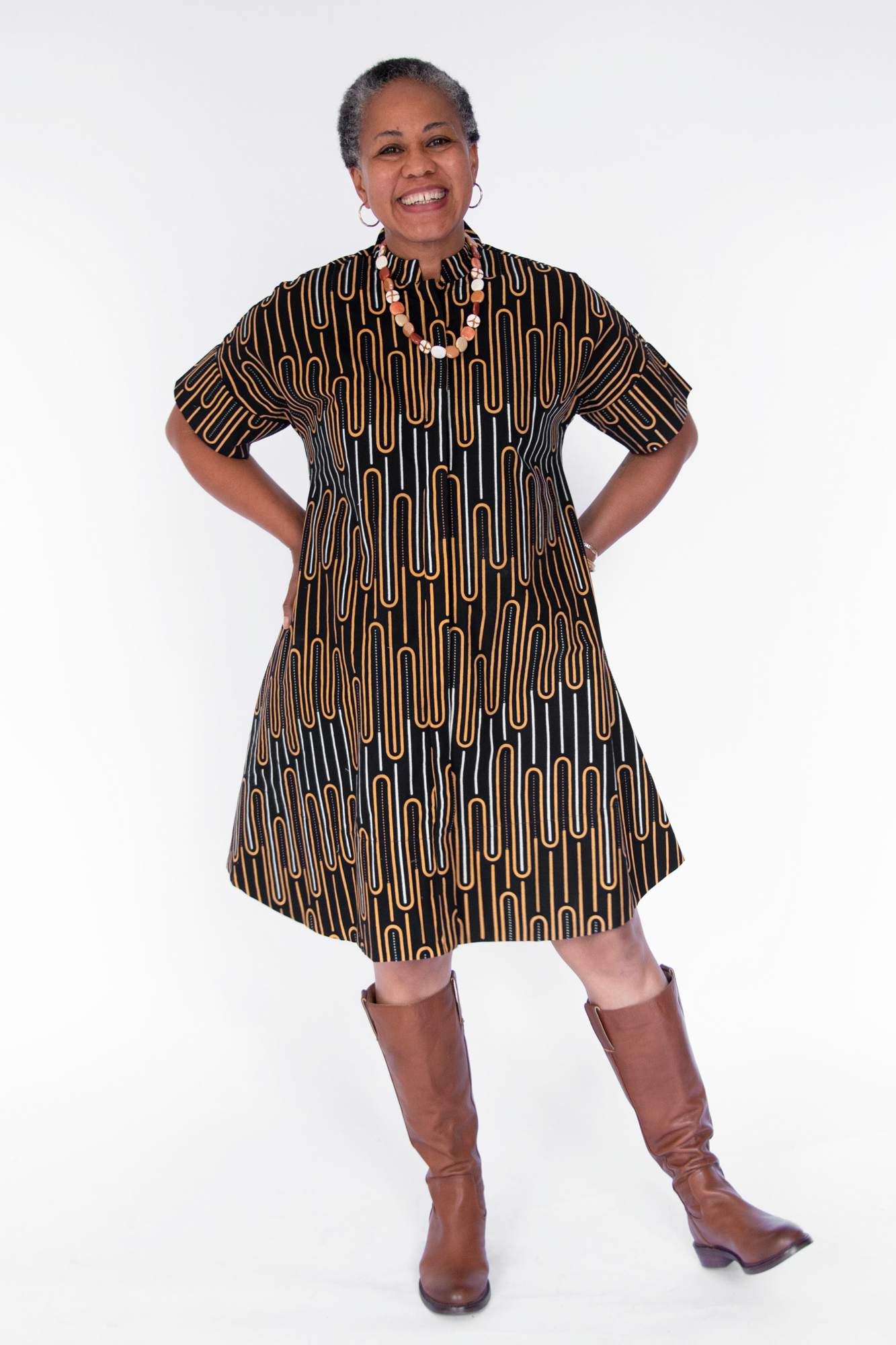 Model wearing deep navy dress with gold and white geometric line print.