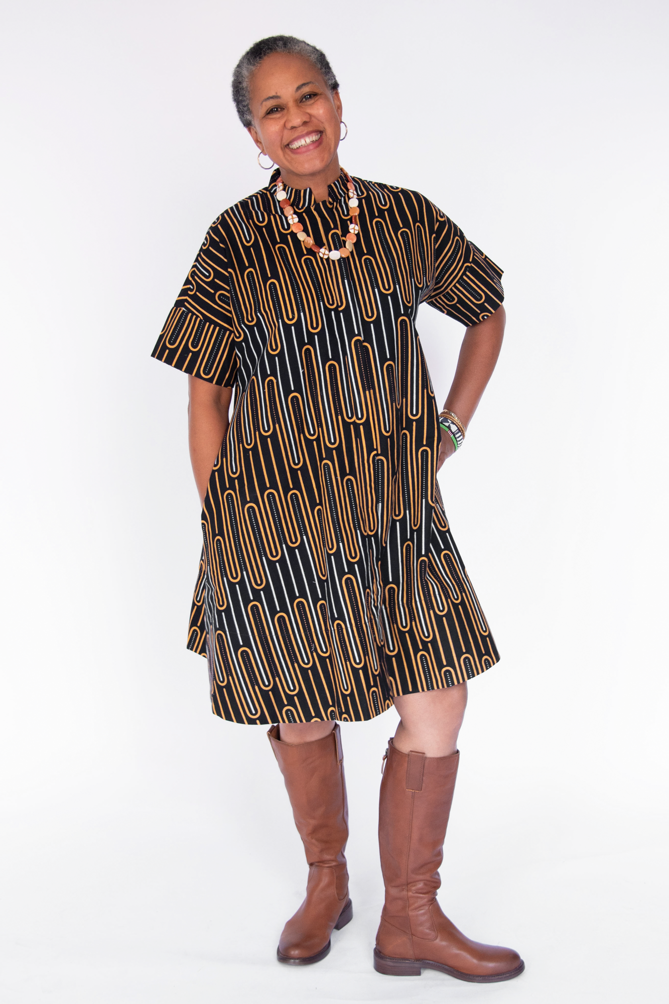 Model wearing deep navy dress with gold and white geometric line print.