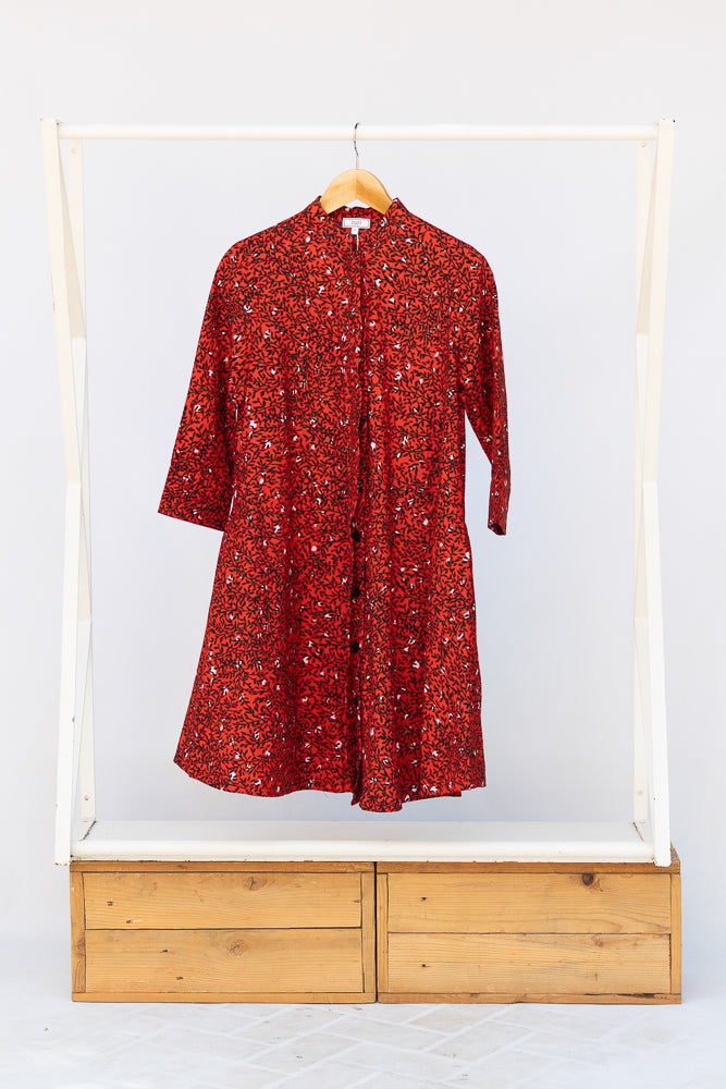 Display of red dress with black and white vine print.