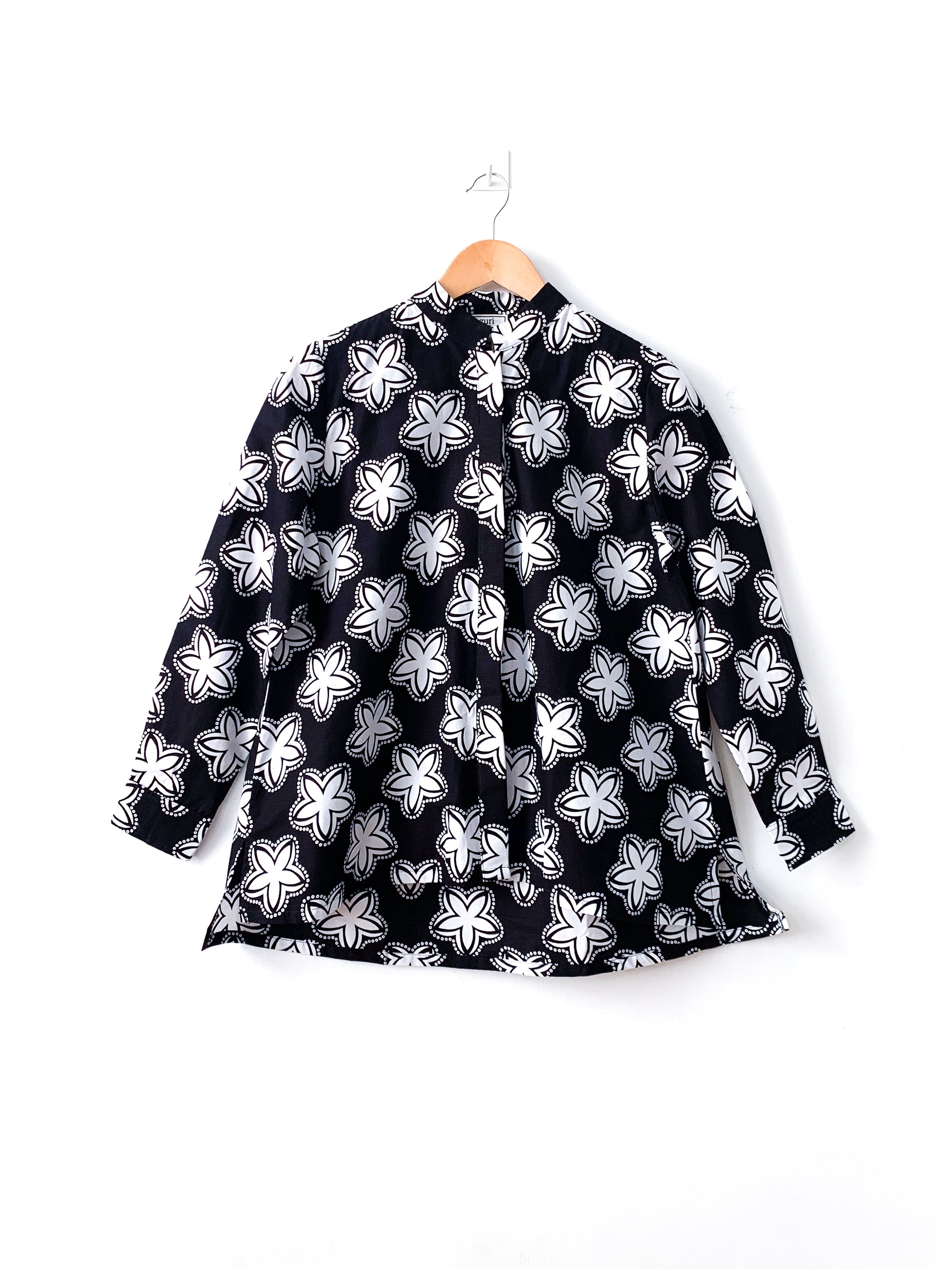 Display of black and white shirt with floral print.