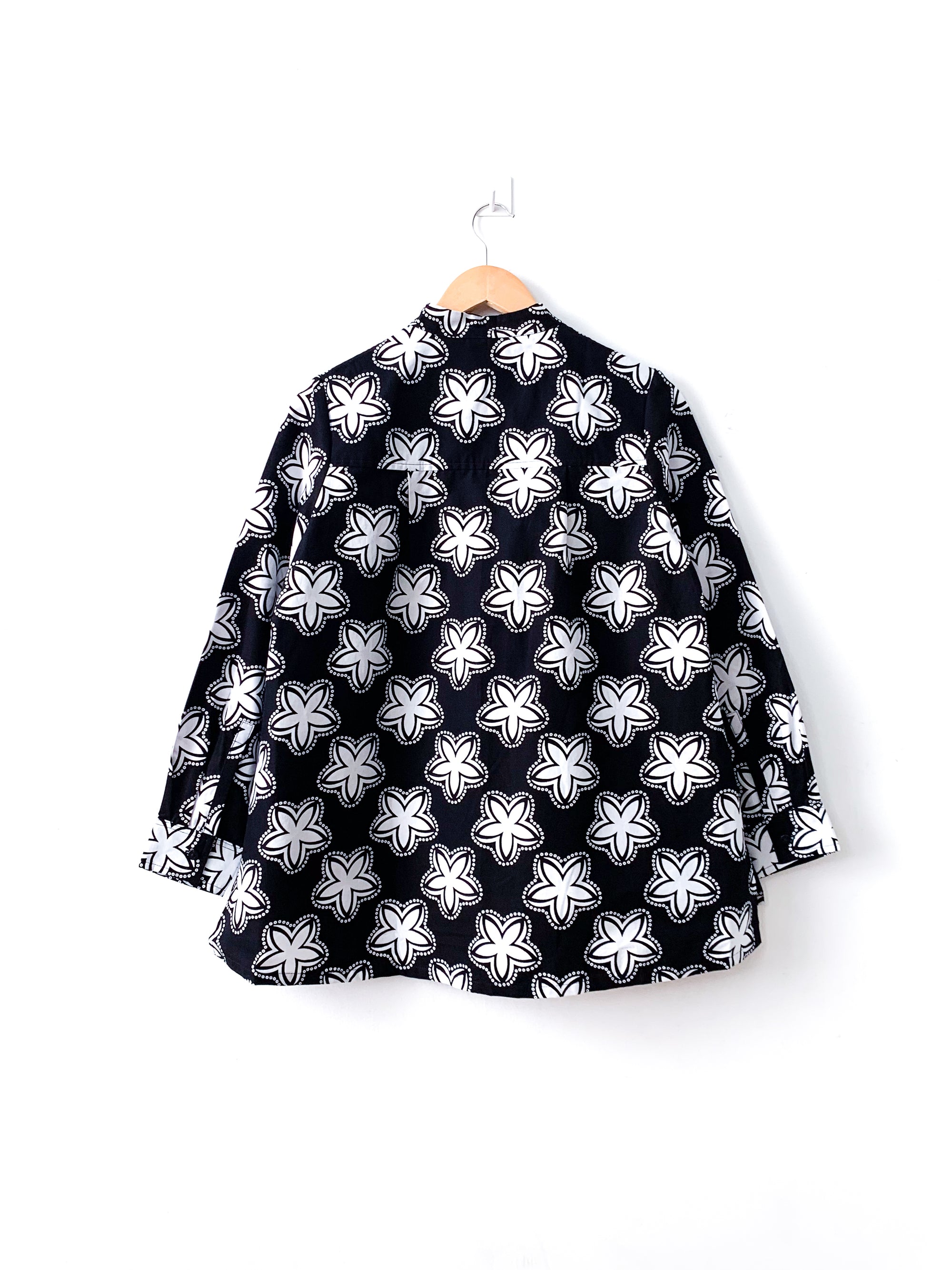 Display of black and white shirt with floral print.