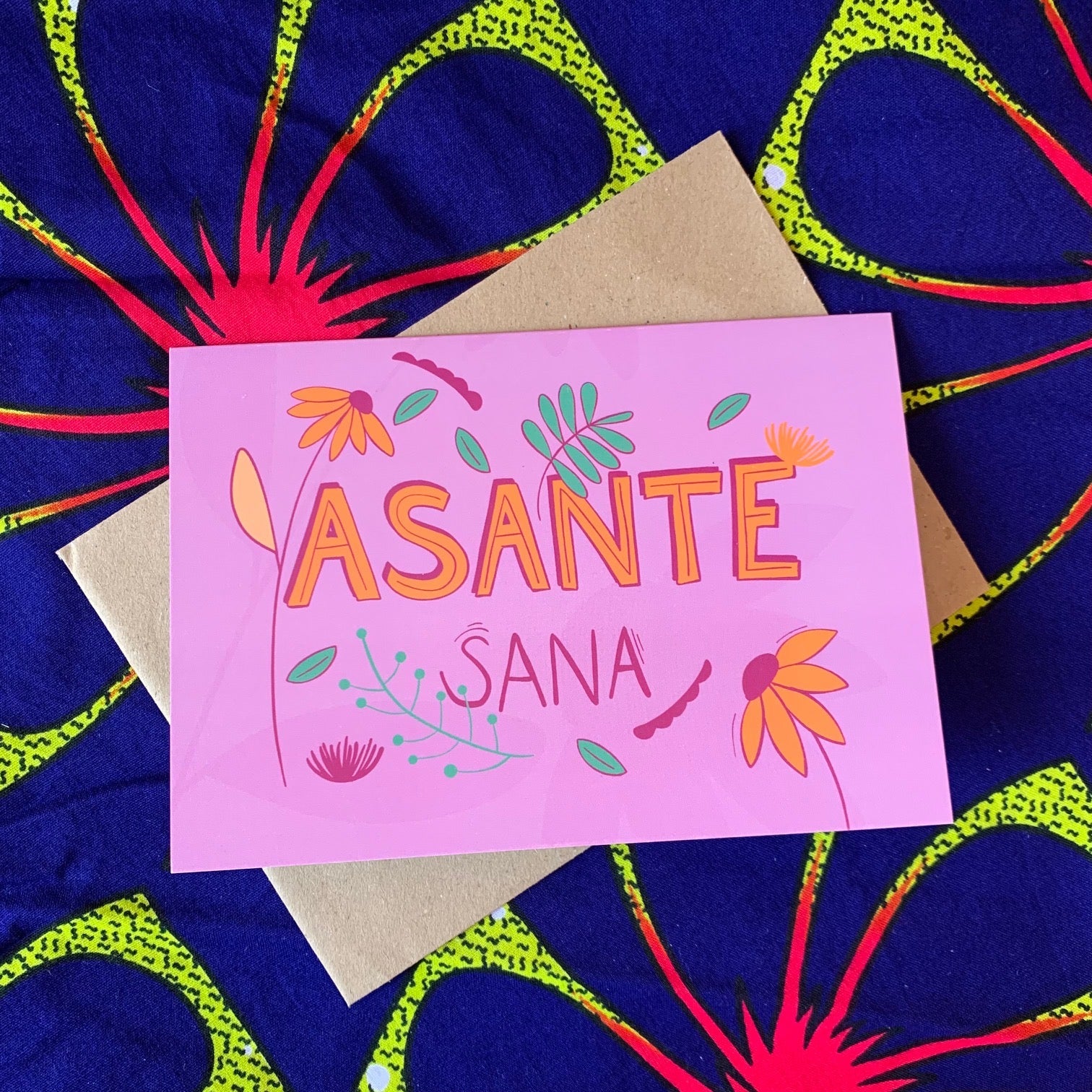 The display of pink floral greeting card with a &quot;Asanta Sana&quot; which means Thank You