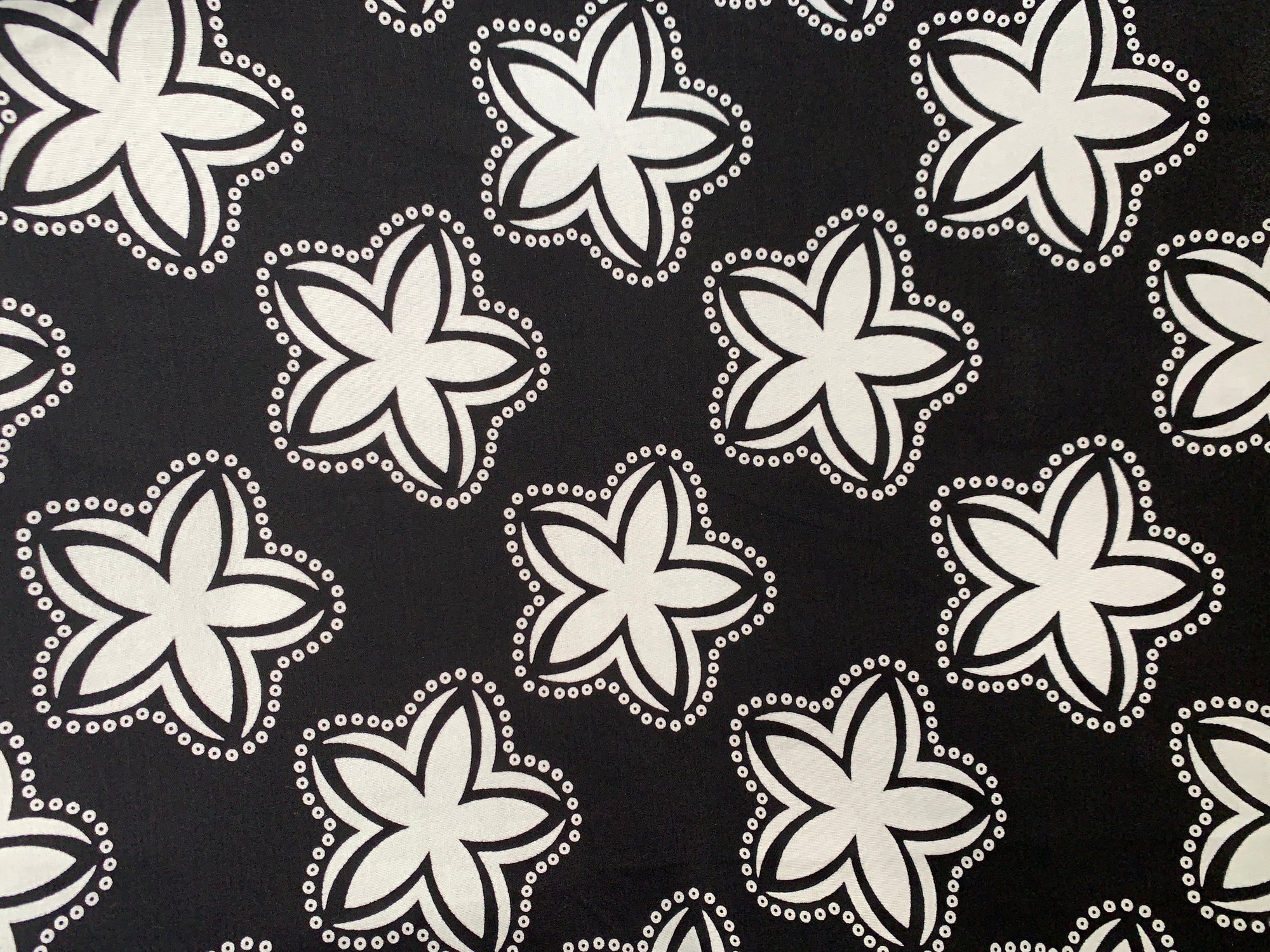 Close up display of black and white shirt with floral print, fabric.