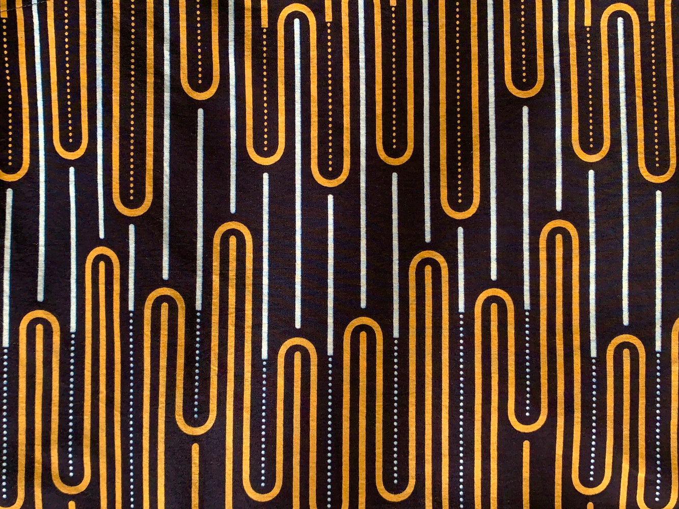 Close up display deep navy dress with gold and white geometric line print, fabric.