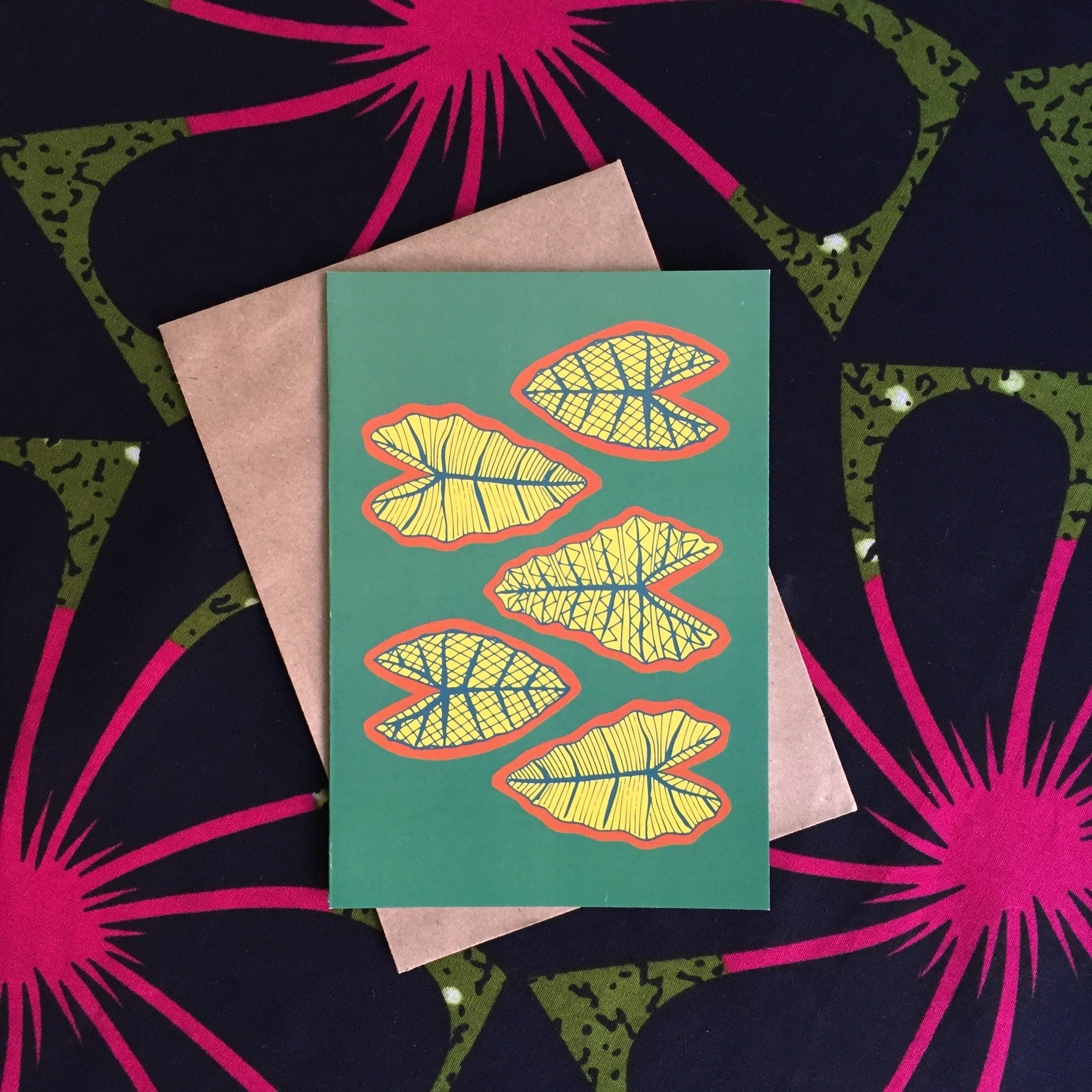 Green greeting card with 4 yellow red and green tropical leaves