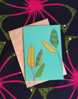 Turquoise Greeting card with yellow, green and red palms